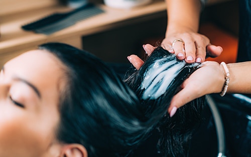 person applying a hair mask to their hair
